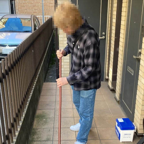 アパート廊下階段部分を清掃する利用者の写真その1